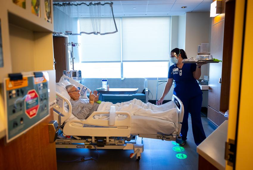 MedSurge Respiratory patient Clyde Alexander gives a wave of thanks to RN Traci Cargile as she carries out his lunch tray at Houston Methodist The Woodlands Hospital on Friday, Jan. 14, 2022. Nurses have taken on several extra roles as hospitals have battled COVID-19 surges since 2020.