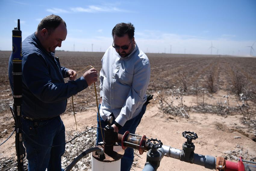 High Plains Underground Water District field technician supervisor Billy Barron, left, and IT and permit administrator Gray Sanders measure a well, Wednesday, May 21, 2025, outside of Slaton.